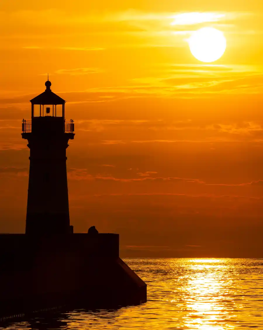 Phare surplombant locean au soleil couchant